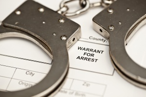 Handcuffs on a warrant for arrest.
